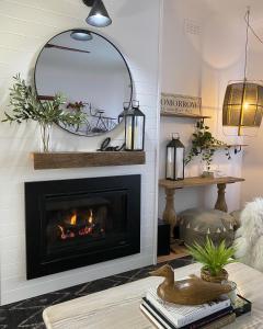 a living room with a fireplace and a mirror at The Miner's Rest in Stawell