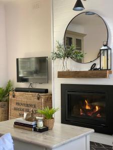 a living room with a fireplace and a mirror at The Miner's Rest in Stawell
