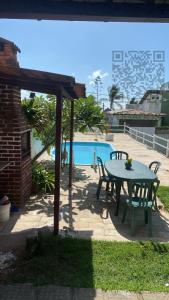 d'une terrasse avec une table et des chaises à côté de la piscine. dans l'établissement CASA DE PRAIA AV BEIRA MAR, à Cabo de Santo Agostinho