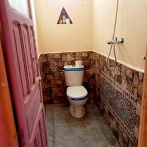 a bathroom with a toilet with a triangle on the wall at Dar Brahim tizgui nbarda in Ouarzazate