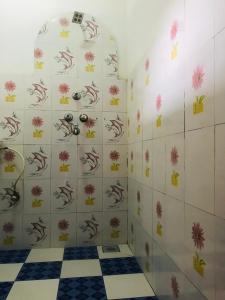 a bathroom with a checkerboard floor and a shower at BABA lodge & restaurant in Sauraha