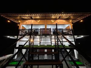 una scala che porta a un edificio di notte di AAHI'S CHILAPATA JUNGLE STAY a Fālākāta