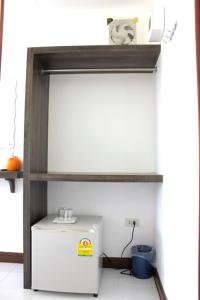 a small white refrigerator in a room with a shelf at Cape Go Resort in Chao Lao Beach
