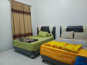 Postel nebo postele na pokoji v ubytování Penginapan Hardsy Homestay Surau Kamba