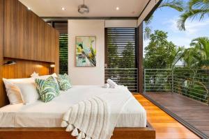1 dormitorio con 1 cama grande en el balcón en 53B Murphy Street - Modern luxury in Port Douglas, en Port Douglas