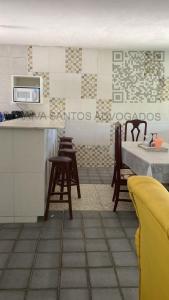 - une cuisine avec une table, des chaises et un comptoir dans l'établissement CASA DE PRAIA AV BEIRA MAR, à Cabo de Santo Agostinho