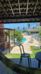une chaise assise dans un hamac sur une terrasse dans l'établissement CASA DE PRAIA AV BEIRA MAR, à Cabo de Santo Agostinho