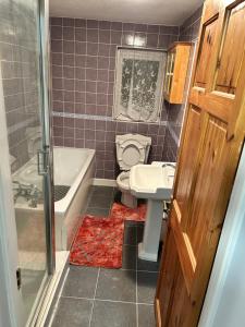 a bathroom with a toilet and a sink and a tub at Comfort at its best! in Gillingham