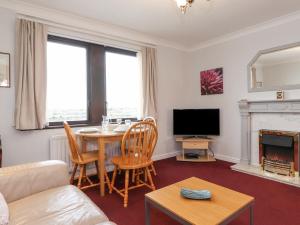 a living room with a table and a tv at Harbour Side in Maryport
