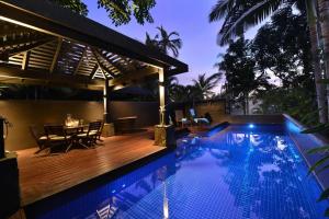 une piscine avec une terrasse en bois et une maison dans l'établissement Hapuka - Luxury Villa with Stunning Views on Murphy St, à Port Douglas