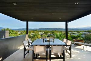 d'une table à manger et de chaises sur un balcon. dans l'établissement Hapuka - Luxury Villa with Stunning Views on Murphy St, à Port Douglas