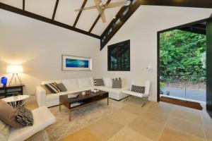 Elle comprend un salon doté d'un mobilier blanc et d'une grande fenêtre. dans l'établissement Hapuka - Luxury Villa with Stunning Views on Murphy St, à Port Douglas