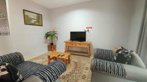 ein Wohnzimmer mit zwei Sofas und einem Fernseher in der Unterkunft Homestay Roma Suite in Kuala Terengganu