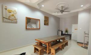 ein Esszimmer mit einem Holztisch und einem Spiegel in der Unterkunft Homestay Roma Suite in Kuala Terengganu
