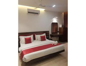 a bedroom with a bed with red and white pillows at Hotel White Tree, Chandigarh in Chandīgarh