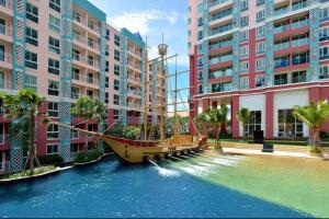 um barco no meio de um rio entre edifícios em Grand Caribbean Condo Resort Pattaya swimming pool balcony em South Pattaya