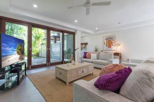 sala de estar con sofá y TV en Tropic Villa at 2/42 Garrick Street, en Port Douglas