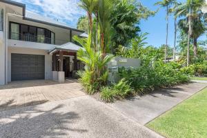 una casa con palmeras y un camino de entrada en Tropic Villa at 2/42 Garrick Street, en Port Douglas