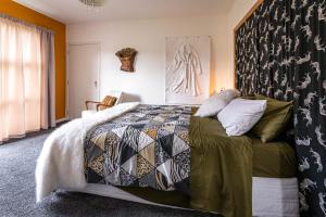 a bedroom with a bed with a comforter and pillows at The Artist's House Wanaka in Luggate