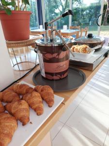 a table with croissants and a cup of coffee and pastries at Hotel Astor in Lido di Classe