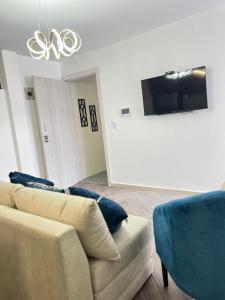 Suit Exclusiva y elegante في ريوبامبا: غرفة معيشة مع أريكة وتلفزيون