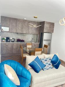 Suit Exclusiva y elegante في ريوبامبا: غرفة معيشة مع أريكة زرقاء ومطبخ