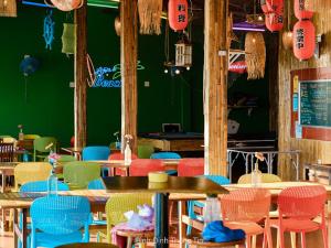 a restaurant with colorful chairs and tables and a green wall at Life's A Beach in Quy Nhon