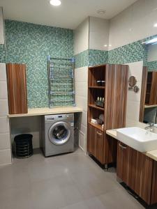 ein Badezimmer mit einer Waschmaschine und einem Waschbecken in der Unterkunft Changchun Clear Moon Apartment by South Lake Hotel in Changchun