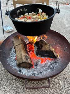 una sartén de comida cocinando en una parrilla con fuego en Casa Olivero, en Navarrés