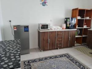 a kitchen with a microwave and a refrigerator at Big Homestay For Big Family 2 With Wi fi in Sungai Petani