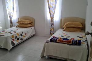 two twin beds in a room with curtains at Big Homestay For Big Family 2 With Wi fi in Sungai Petani