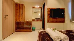 bagno con doccia e TV in camera di HOTEL SAPPHIRE INN a Thane