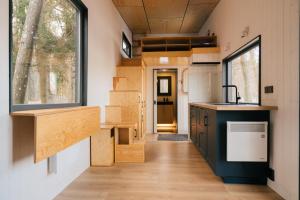 a tiny house with a kitchen and a hallway at Living art piece at the lake. 