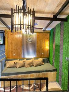 a bench in a room with green walls and a chandelier at Holyghost Veranda Baguio Transient Guest House 42 step rooftop in Baguio