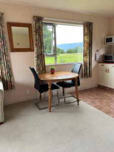 a dining room with a table and chairs and a window at Carrickfergus Cottage Unit 2 in Harihari