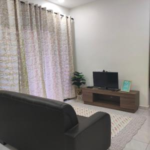 Homestay HABI Residence في Kepala Batas: غرفة معيشة مع أريكة وتلفزيون