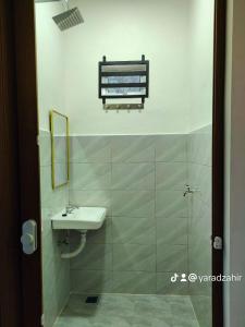 a bathroom with a sink and a mirror at Homestay HABI Residence in Kepala Batas
