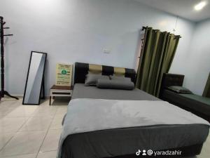 a bedroom with a large bed and a couch at Homestay HABI Residence in Kepala Batas