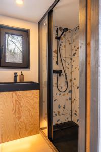 a shower in a bathroom with a glass door at Living art piece at the lake. 