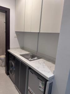 a kitchen with a sink and a washing machine at Luxury apartment in a tower شقه فاخرة في برج اللؤلؤة in Riyadh