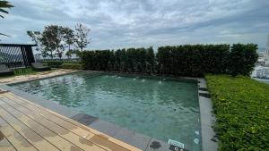 - une piscine dans une cour avec une terrasse en bois dans l'établissement Bali-style 2Bedroom Condo @ Georgetown, à George Town