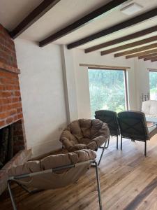uma sala de estar com duas cadeiras e um sofá em Steingarten, Casa de Campo hermosa y amoblada. em Riobamba