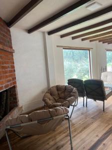 a living room with two chairs and a couch at Steingarten, Casa de Campo hermosa y amoblada. in Riobamba