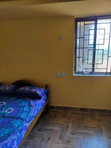 1 dormitorio con cama y ventana en Edward's Home Stay, en Sriperumbudur