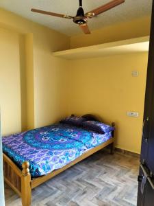 Cama en habitación con ventilador de techo en Edward's Home Stay, en Sriperumbudur