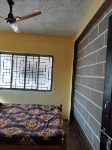 1 dormitorio con cama y ventana en Edward's Home Stay, en Sriperumbudur