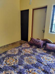 Un dormitorio con una cama azul con almohadas. en Edward's Home Stay, en Sriperumbudur