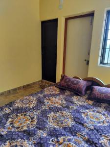 a bedroom with a blue bed with pillows on it at Edward's Home Stay in Sriperumbudur