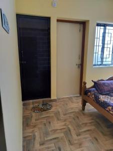 a room with a door and a wooden floor at Edward's Home Stay in Sriperumbudur