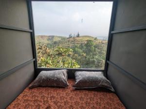 ventana con 2 almohadas y vistas a la montaña en Spirit of the Wild Retreat @ IMark Valley, en Attappādi